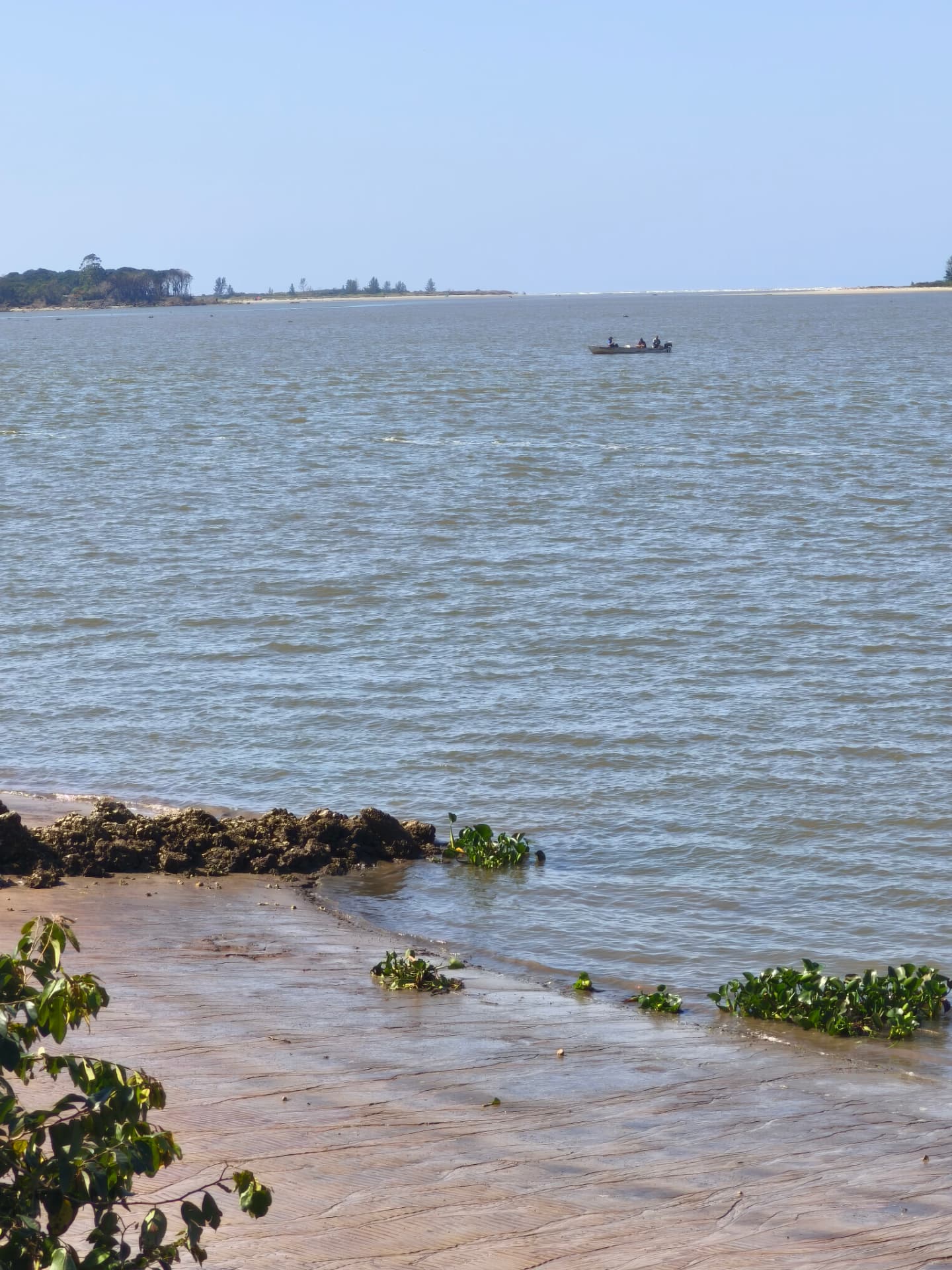 Rio calmo com barco de pescadores ao longe